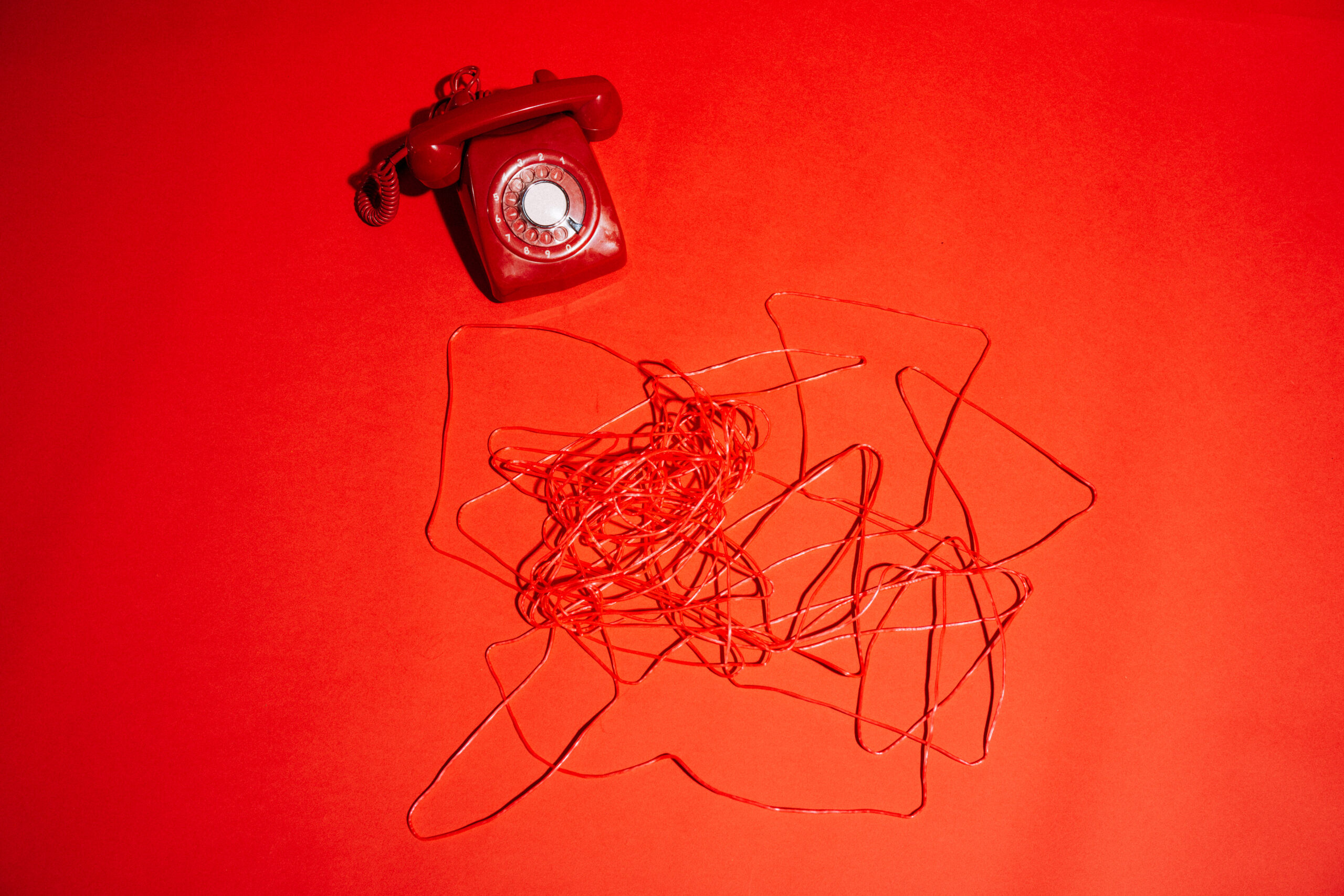 Telefon und Kabel auf rotem Hintergrund
