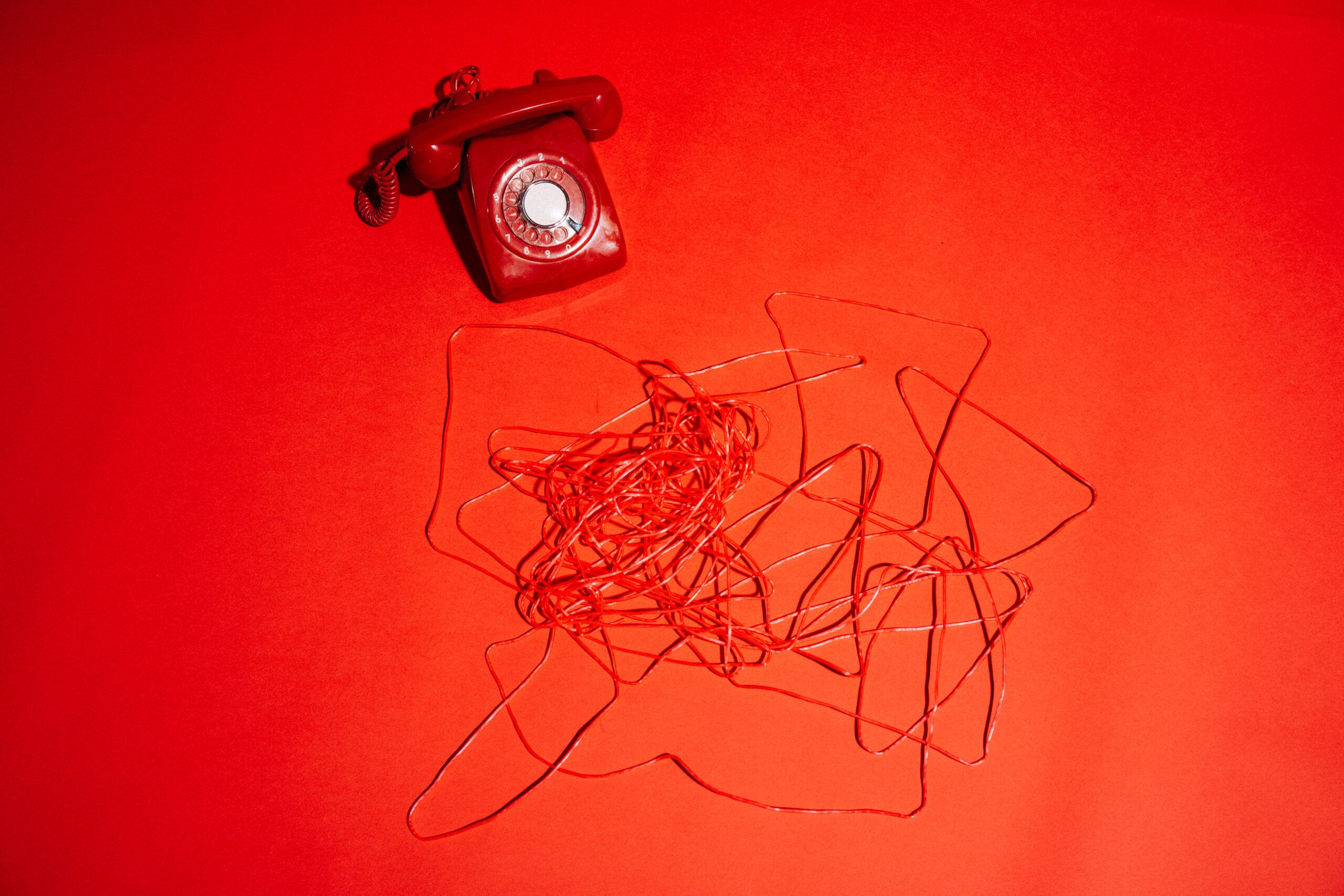 Telefon und Kabel auf rotem Hintergrund