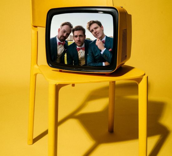 Hochzeitsband München Zanadu – Bandmitglieder als Köpfe in einem gelben Retro-Fernseher