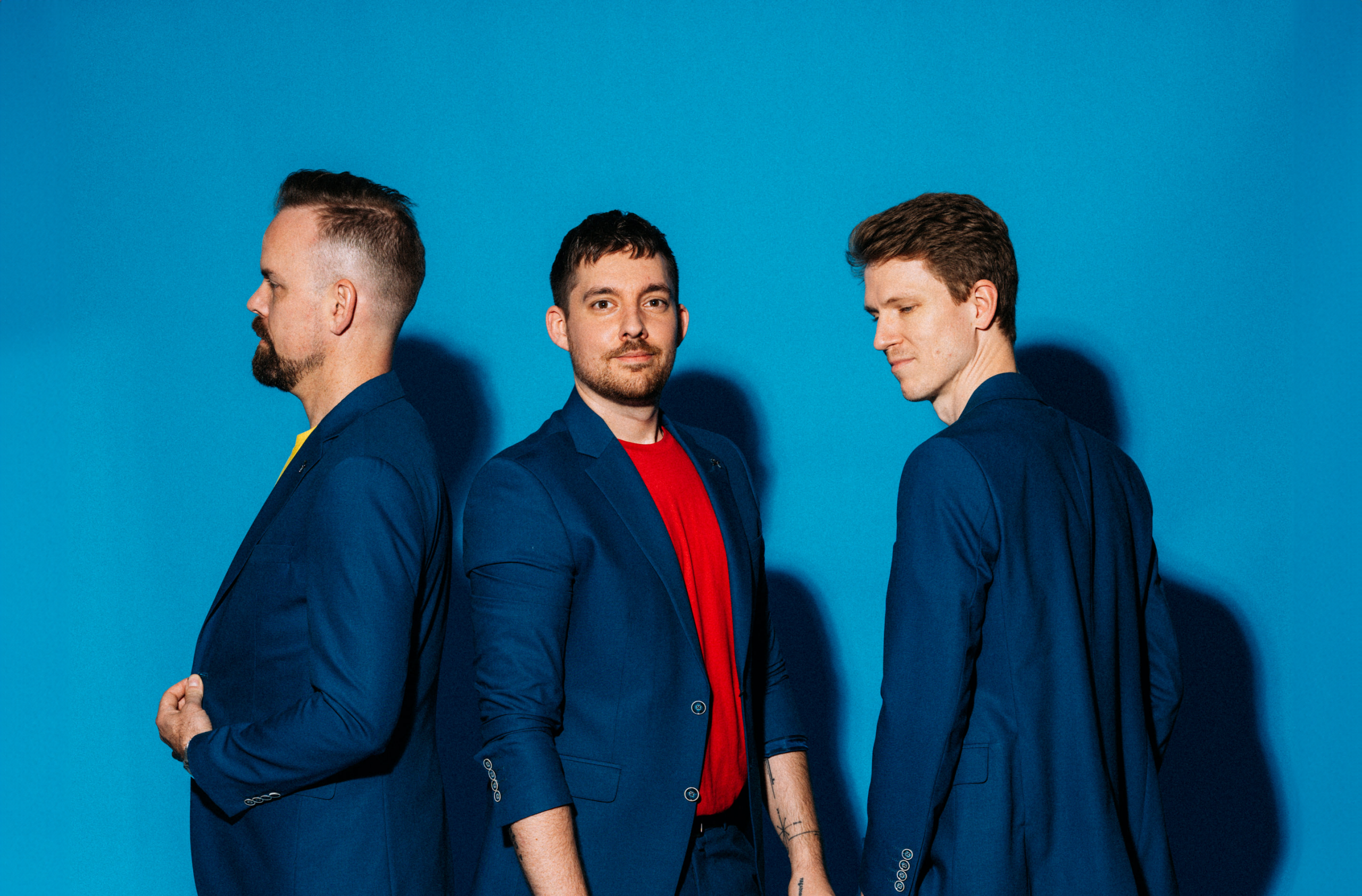 Musikeer stehen im Firmen Bekleidung vor blauer Wand